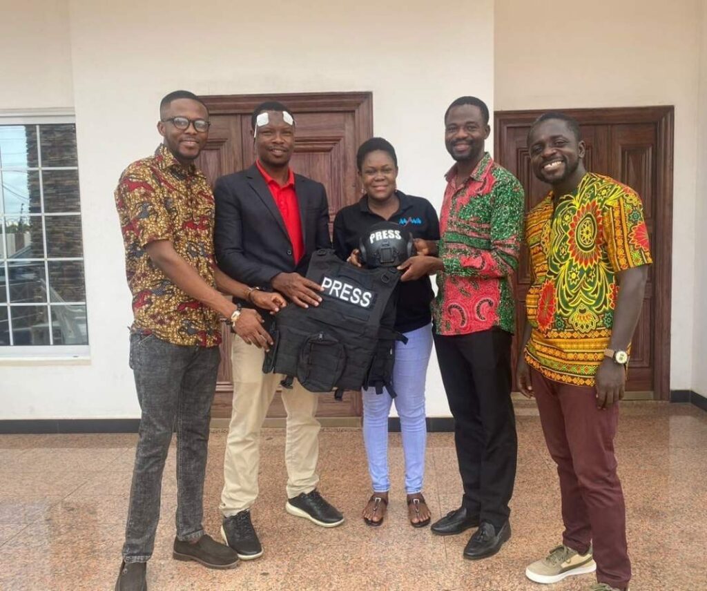 Founder of Journalists Sanctuary International presenting protective equipment (Military standard helmet and bulletproof vest) to investigative journalist Manaseh Azure Awine and staff of The Fourth Estate